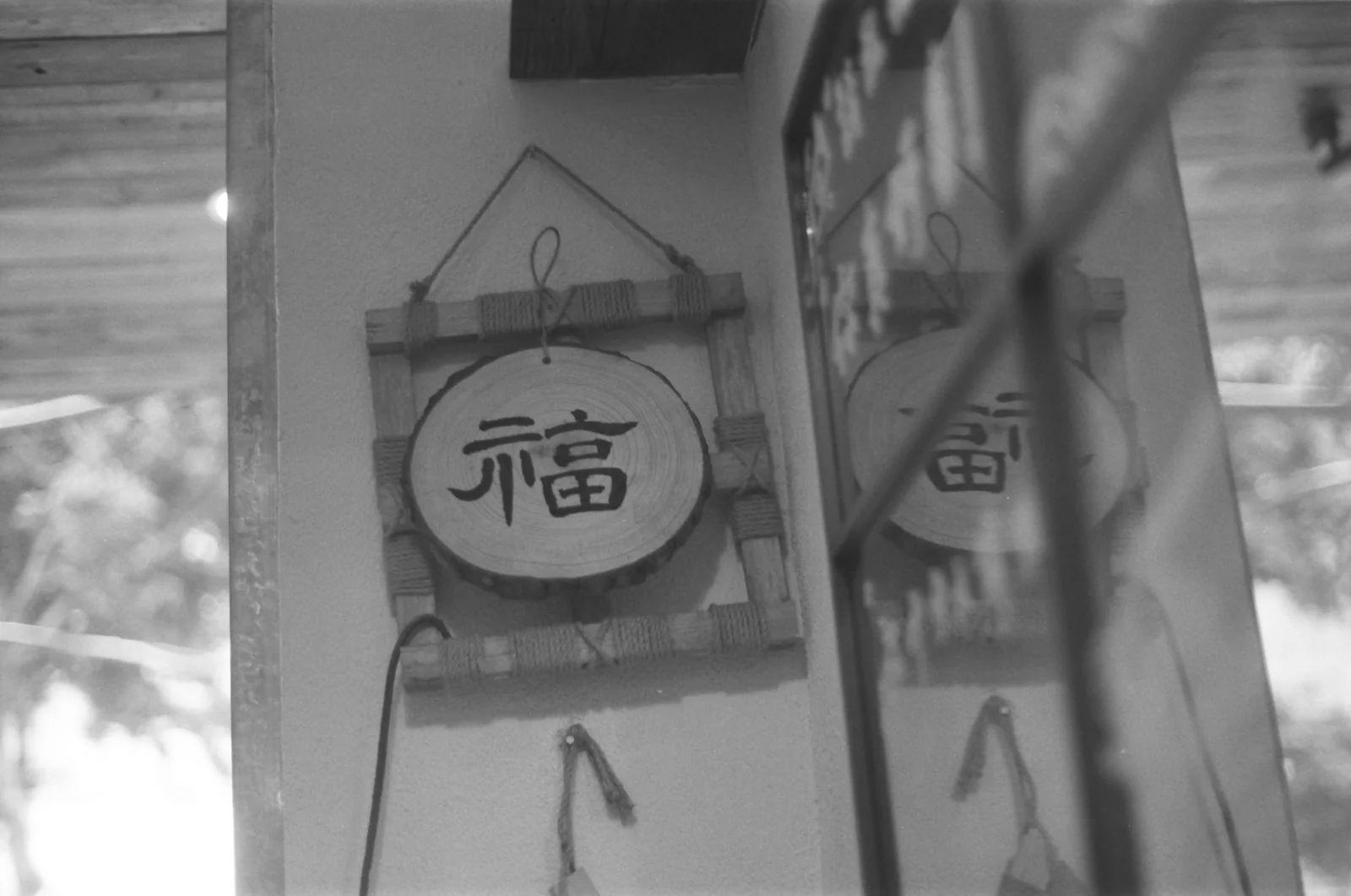 黑白画面里写着福字的门牌与玻璃反光