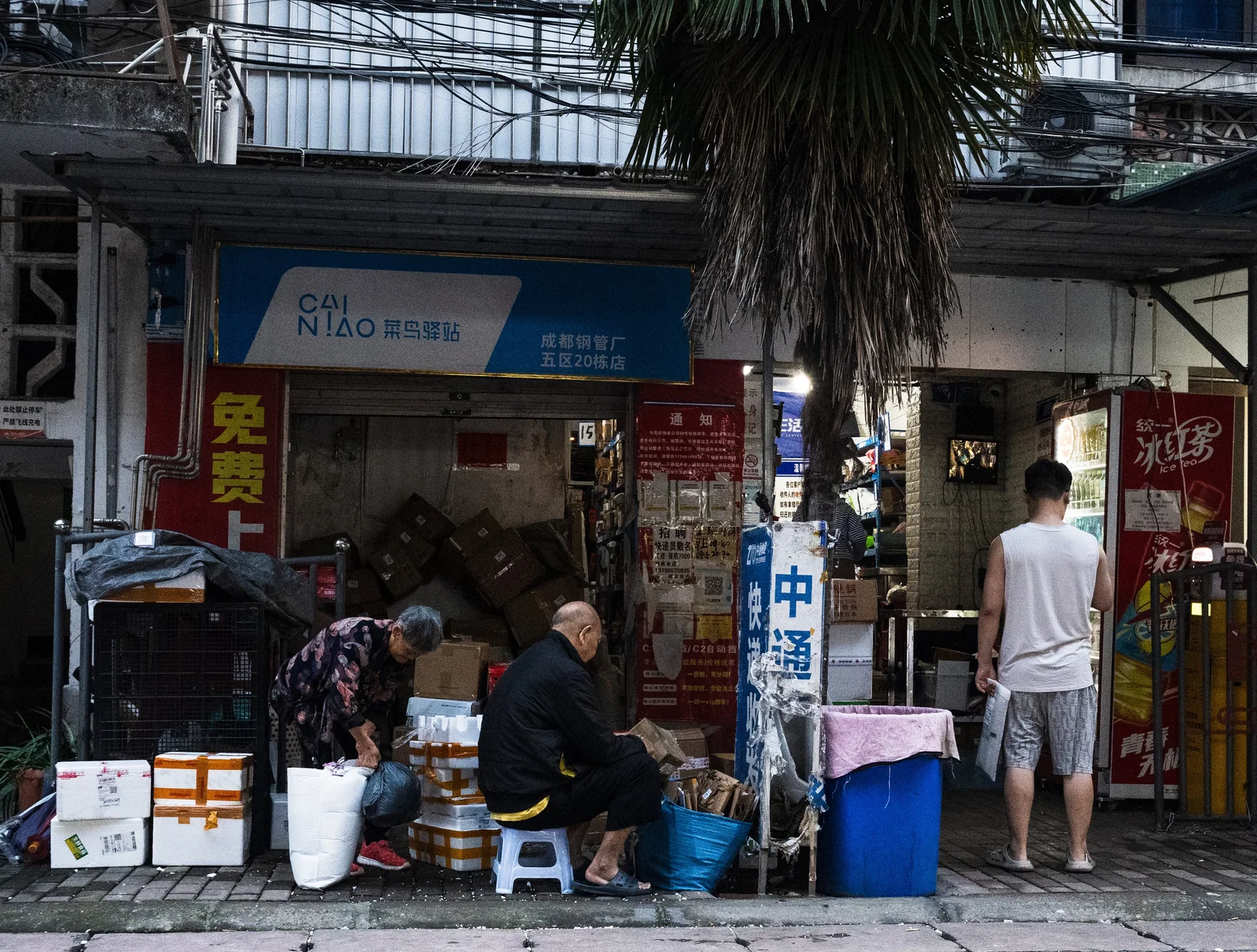 夜间店铺前交谈的人与门口的灯光