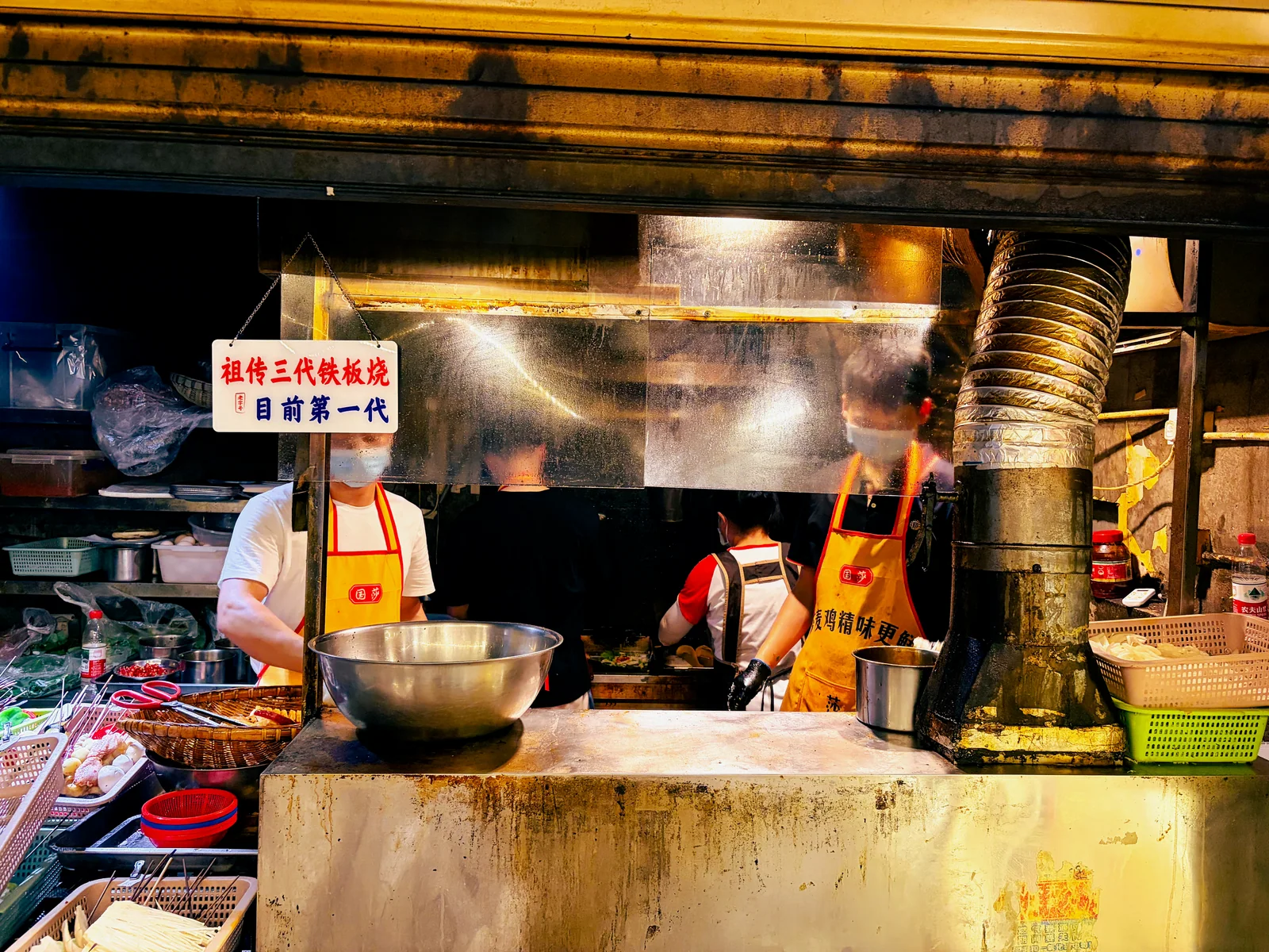 夜间摊位上的锅具、蒸汽与忙碌的人