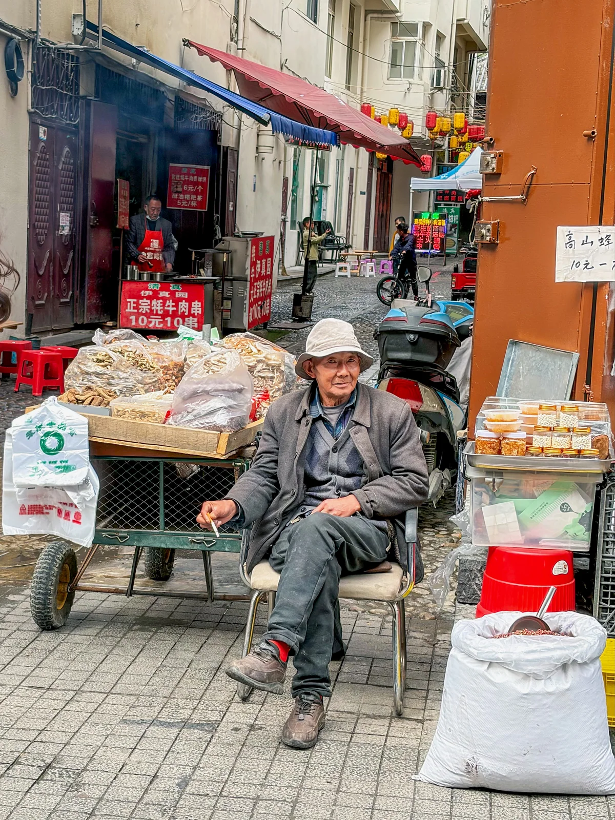 摊位前戴口罩的老人坐在椅子上