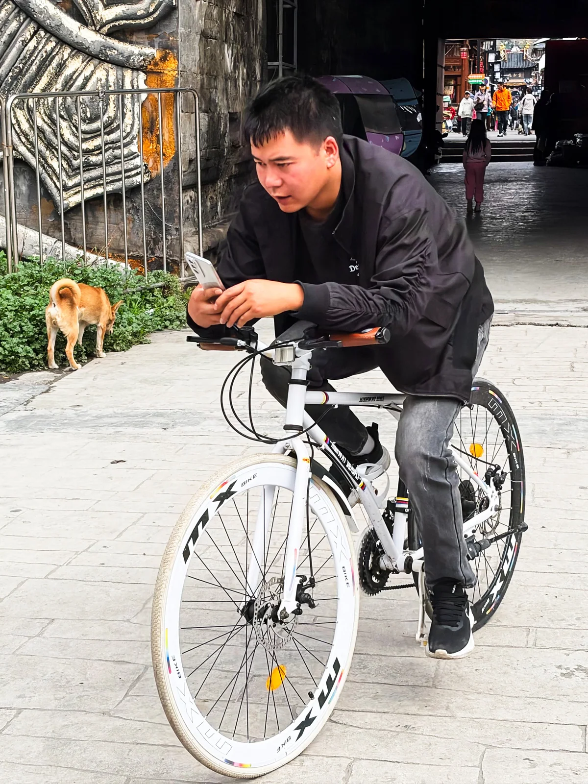 男子骑自行车经过街边店铺